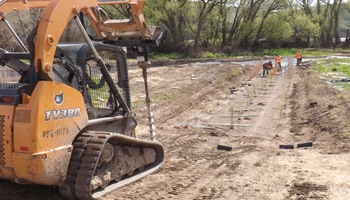 Heavy equipment contouring the earth for planting