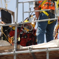 Diver entering steel water storage tank 